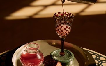 Bar detail at Amanbagh showing cocktail being poured over ice in a geometric glass.