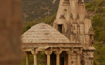 Historic cenotaph at Amanbagh, viewed through architectural detail with domed pavilion and ornate columns.