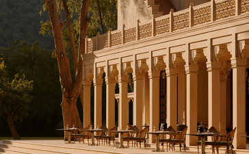 Amanbagh restaurant terrace with columned architecture and dining seating overlooking grounds at dusk.