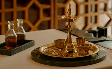 Spa treatment bottles and brass bell on marble table at Amanbagh, India.