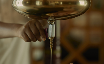 Therapist pouring warm oil over guest's face during Ayurvedic treatment at Amanbagh spa.