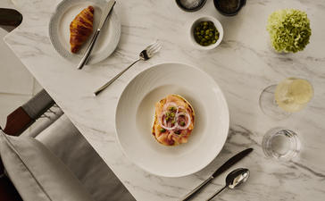 Amanera breakfast table setting with pasta dish and fresh ingredients in bowls.