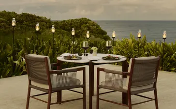 Comedor privado al aire libre en Amanera resort, con vistas al mar y vegetación tropical.