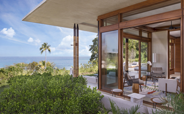 Amanera casita terrace overlooking lush hillside landscape with open glass doors.