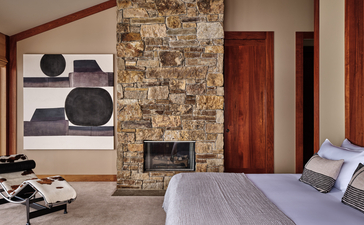 Principal bedroom at Amangani with stone fireplace and mountain views.