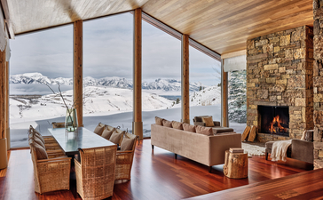 Wapiti Home at Amangani with floor-to-ceiling windows overlooking snow-covered Jackson Hole valley and fireplace.