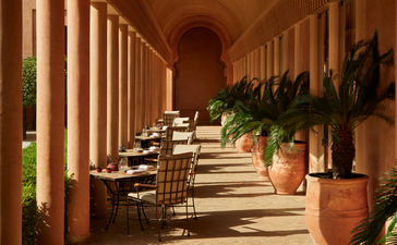 安缦珍纳度假村餐厅走廊，两侧陈列陶土花盆，柱廊延伸至远处。