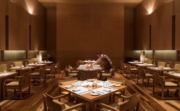 Amankora dining room in Thimphu with warm wood tones, soft lighting, and formally set tables for service.