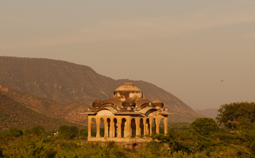 Neoclassical pavilion illuminated at dusk in the Aravalli hills at Amanbagh.
