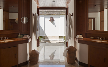 Duplex pool suite bathroom at Amandari with dual vanities, marble flooring, and view to terrace beyond.