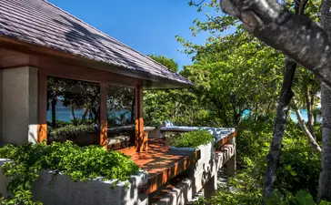 Villa à trois chambres à Amanpulo, avec terrasse ombragée et jardins tropicaux.