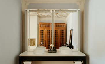 安缦威尼斯酒店Alcova Tiepolo套房浴室的梳妆台，配有镜子和洗护用品。