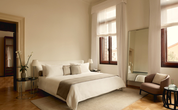 Chambre avec lit blanc, miroirs et fenêtres lumineuses, Aman Venice.