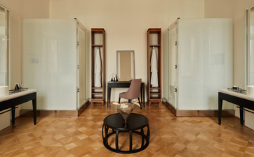 アマン ヴェニスのコッキーナスアパートメント、パパドポーリの浴室。木製フローリング、ベージュ調の壁、左右に洗面台、中央に浴槽。