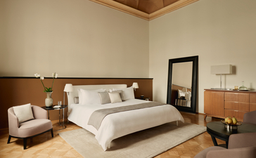 Camera da letto con letto matrimoniale, parete in legno e arredamento minimalista ad Aman Venice.
