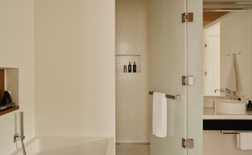 Salle de bains spacieuse de la suite Grand Canal à Aman Venice, avec éléments minimalistes et finitions claires.