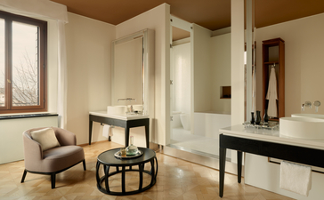 安缦威尼斯酒店浴室内，配有独立浴缸、淋浴间和休息区，整体设计简洁优雅。