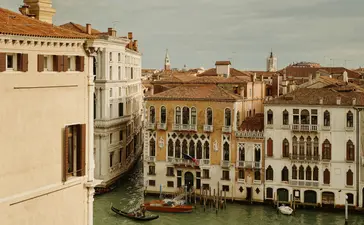 Palazzo chamber at Aman Venice hotel with views across the Grand Canal and venetian architecture.