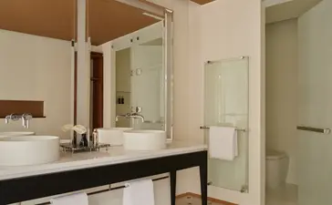 Salle de bains du Palazzo Stanza avec lavabo double et miroir, Aman Venice.