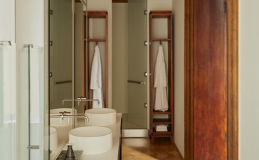 Salle de bains de la Stanza Sansovino à Aman Venice, avec lavabo et miroirs encadrés.
