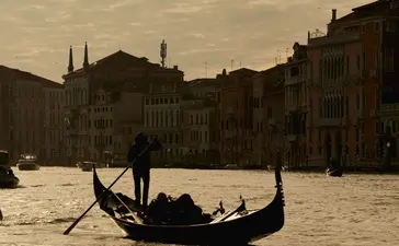 Gondola on the Grand Canal at Aman Venice hotel, Venice exterior view at dusk.