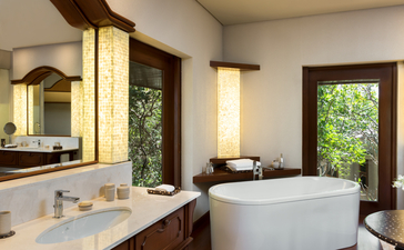 アマンプロ リゾートのツーベッドルームヴィラ バスルーム。白い浴槽と木製の洗面台がある。