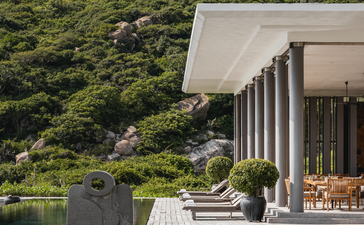 Ben Richards photograph of a modern pavilion extending over water towards forested hillside at Amanoi.