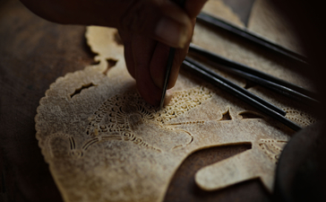 Artisan hands shaping stone at Amanjiwo resort, Yogyakarta.
