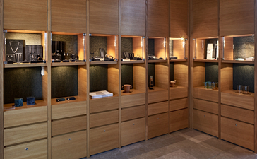 アマンゾイ リゾートのメインブティックで、照明付きの木製展示棚に商品が並べられている。