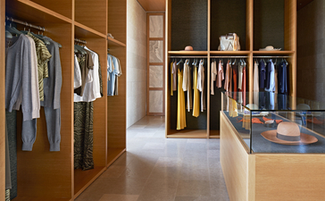 アマンゾイ リゾートのメインブティックで、木製のキャビネットに整理された衣類が展示されている。