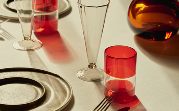 アマン ヴェニスのホテルレストランで、赤いドリンクが置かれた白いダイニングテーブルの設定。