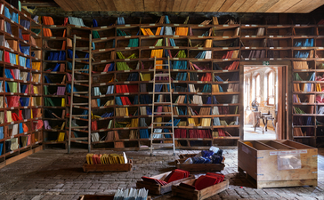 Orsoni mosaic studio in Venice, walls lined with colourful glass tiles and tools scattered across the workspace.