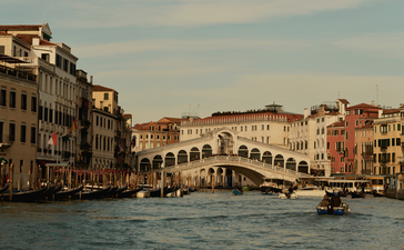 Rialto Bridge spanning the Grand Canal at Aman Venice, with historic buildings lining the waterway.