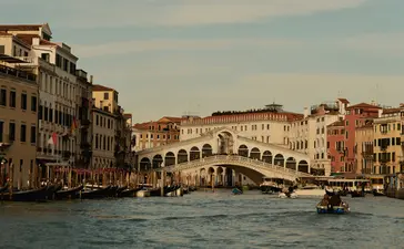 Rialto Bridge spanning the Grand Canal at Aman Venice, with historic buildings lining the waterway.