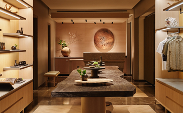Spa e wellness retail space at Aman New York, con scaffali in legno e prodotti esposti sotto illuminazione calda.