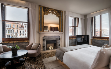 Suite with fireplace and Grand Canal views at Aman Venice hotel.