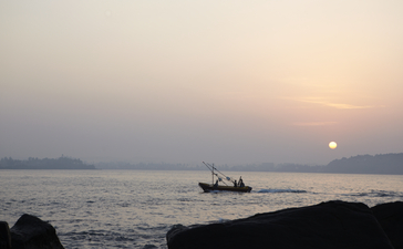 Fishing boat silhouetted against a golden sunset at Amangalla, Sri Lanka.