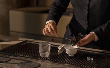 Executive at desk in Amanyangyun, reviewing documents with water glass nearby.