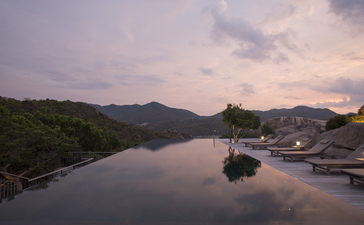 Amanoi resort এ শান্ত জলের উপর সন্ধ্যার আলো ছড়িয়ে পড়ছে।