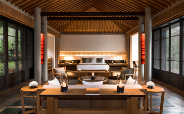 安缦诺怡度假村的木制套房内部，展示温暖的灯光、传统家具和宽敞的布局。