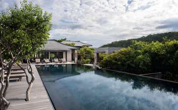 Amanoi resort-এ পুল ডেক থেকে অসীম প্রান্তিক পুল এবং নদীর দৃশ্য।