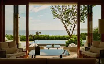 Amanera casita interior with open doors framing plunge pool and countryside views beyond.