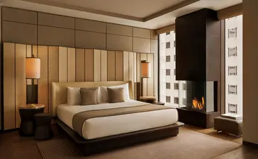 Chambre principale de la Grand Suite à Aman New York, avec lit king-size et panneaux muraux capitonnés.