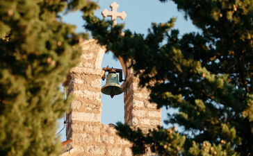 Stone tower framed by pine trees at Aman Sveti Stefan, Montenegro.