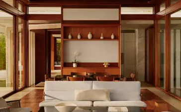 Sala de estar con sofá blanco y chimenea de madera en Casa de dos dormitorios, Amanera Resort.