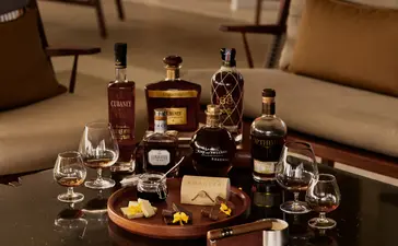 Rum and chocolate tasting display at Amanera resort, featuring bottles and glasses arranged on a wooden board.