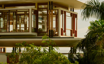 Exterior view of a raised Casa Grande residence at Amanera resort, with wooden architecture and tropical vegetation.