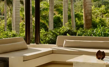 Amanera resort lobby with curved seating, wooden columns, and views of Dominican landscape.