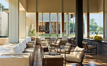 Amanwella interior lounge with high ceilings, floor-to-ceiling windows and natural daylight streaming across neutral furnishings.