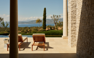 Deluxe pool pavilion at Amanzoe with lounge chairs overlooking Aegean Sea views.